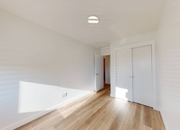 A room with a wooden floor and white walls.