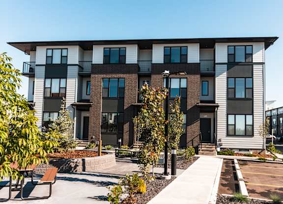 A modern apartment building with a courtyard and benches.