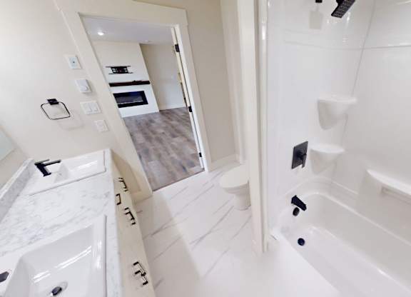 A white bathroom with a walk in shower and a sink.