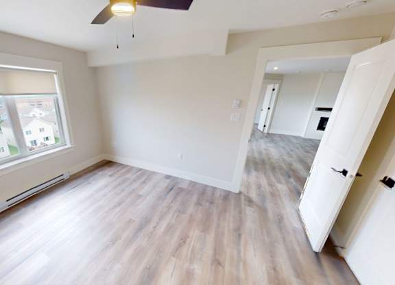 A room with a window and a ceiling fan.