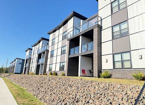 A modern building with a stone wall in front.