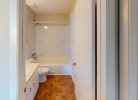 A bathroom with a toilet, sink, and bathtub.