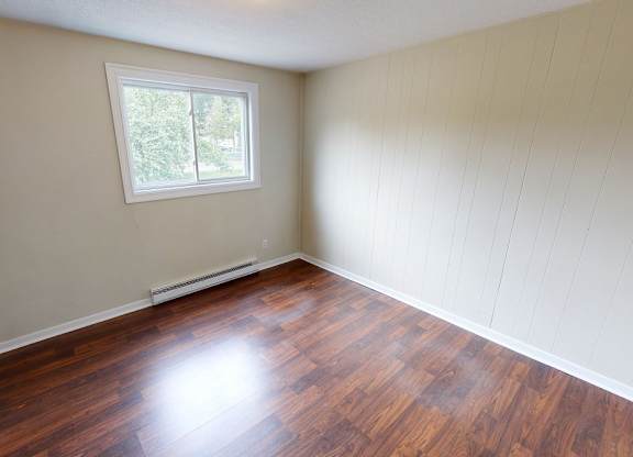 A room with wooden floors and a window.
