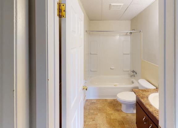 A bathroom with a toilet, sink, and bathtub.