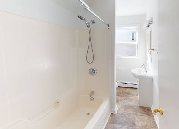 A white bathroom with a tub and a shower.