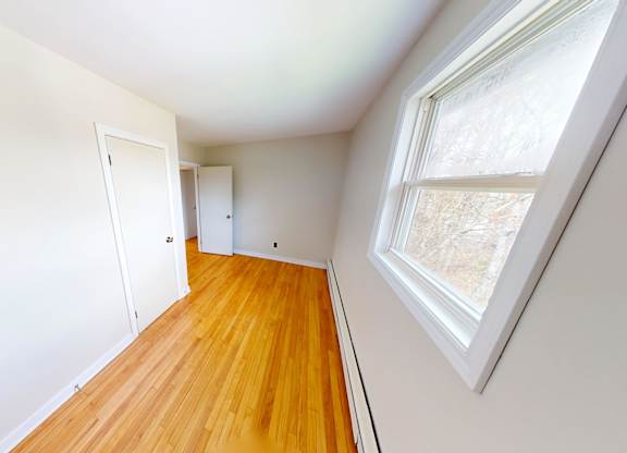 A room with a wooden floor and a window.