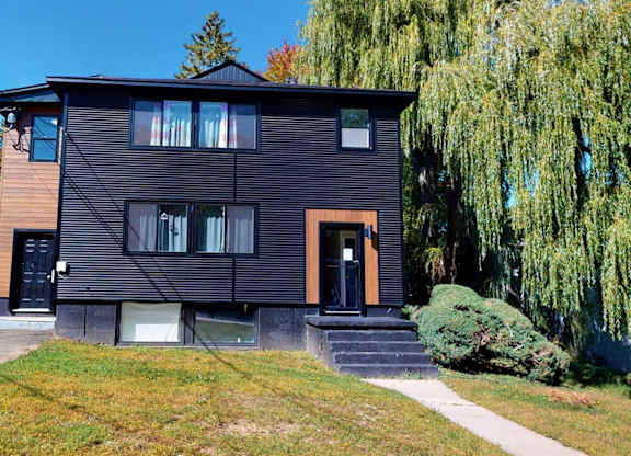 A black house with a brown door and windows.