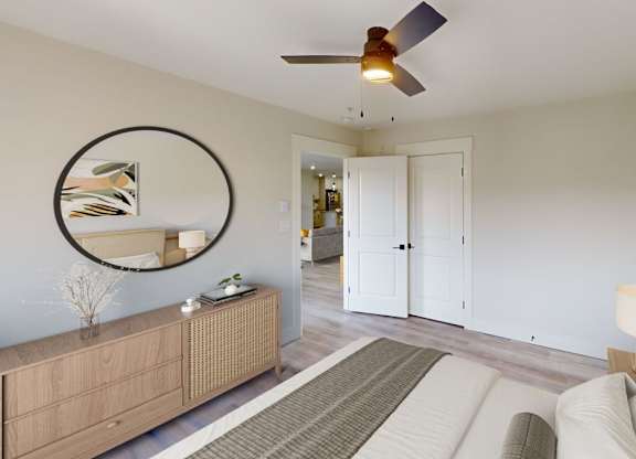 A living room with a brown rug, a white sofa, a wooden cabinet, a round mirror, and a ceiling fan.