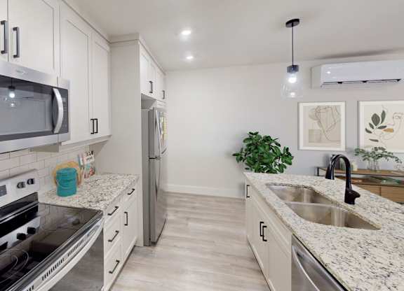 A modern kitchen with stainless steel appliances and a marble countertop.