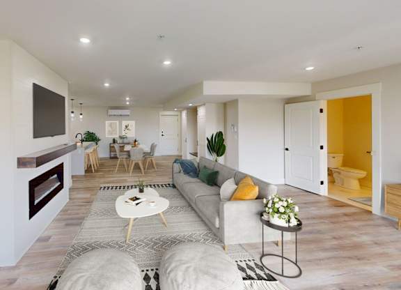 A modern living room with a grey sofa, a coffee table, and a TV mounted on the wall.