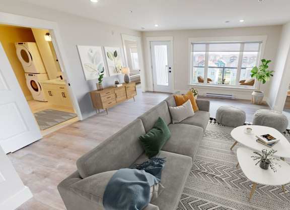 A living room with a grey sofa and a white coffee table.