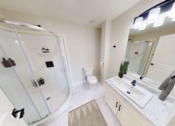 A modern bathroom with a glass shower stall and a sink vanity.