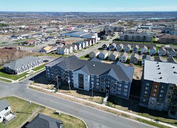 A large apartment complex sits in the middle of a suburban neighborhood.