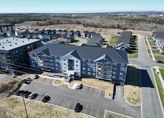 A large building complex with a parking lot in front.