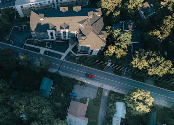A bird's eye view of a road with a car stopped at a red light.