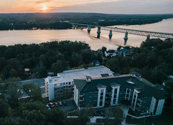 A bridge spans a river in the distance, with a building in the foreground.