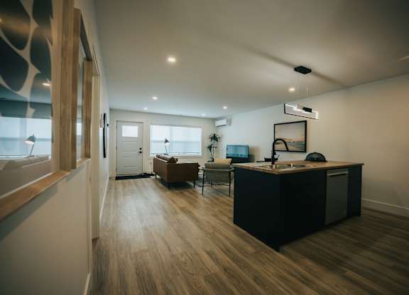 A modern kitchen with a wooden floor and a large island.