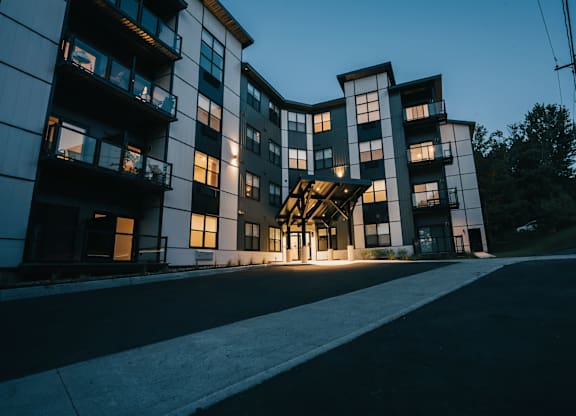 A modern apartment building with a curved design and multiple balconies.