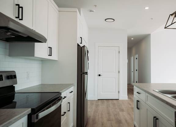 A kitchen with a black counter top and white cabinets.