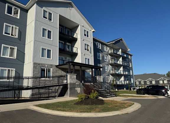 A large apartment building with a black fence in front.