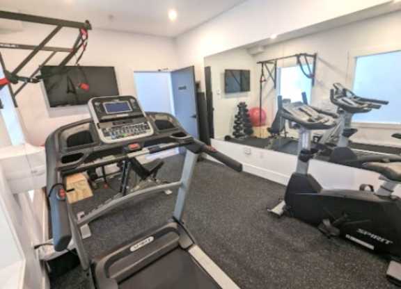 A treadmill and a stationary bike are in a well-lit room.