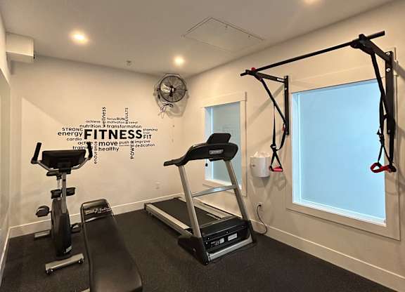 A gym with a pull up bar and a mirror.