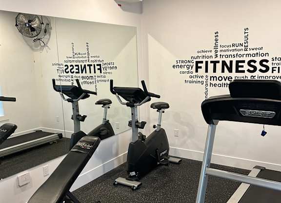 A gym with a treadmill and a sign that says "FITNESS".