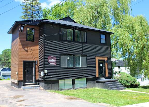 A black house with a red sign on the front.