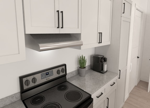 A modern kitchen with a black stove top oven and white cabinets.