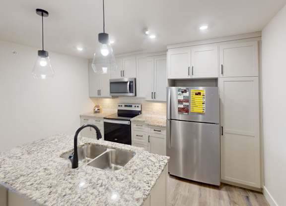 A kitchen with a granite countertop and stainless steel appliances.