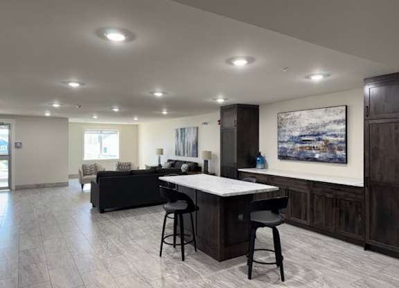A modern kitchen with a bar area and a painting on the wall.