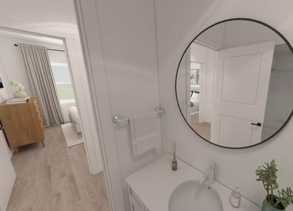 A bathroom with a round mirror and a white sink.