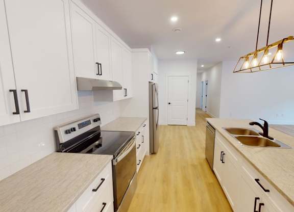 A kitchen with white cabinets and a wooden countertop.