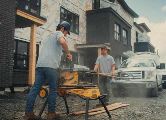A man is sawing wood on a construction site.