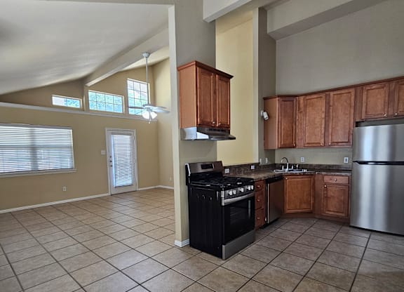 A kitchen with a black stove top oven and a silver refrigerator.