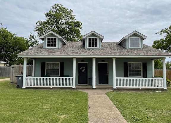 A house with a grey roof and a green front.
