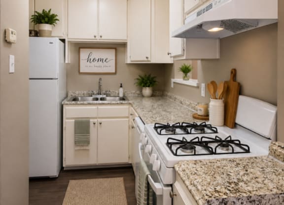 A kitchen with a white stove and cabinets.