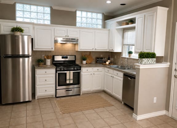 A kitchen with white cabinets and a stainless steel refrigerator.