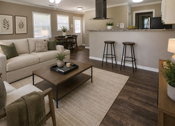 A living room with a white couch, a coffee table, and a bar area with stools.