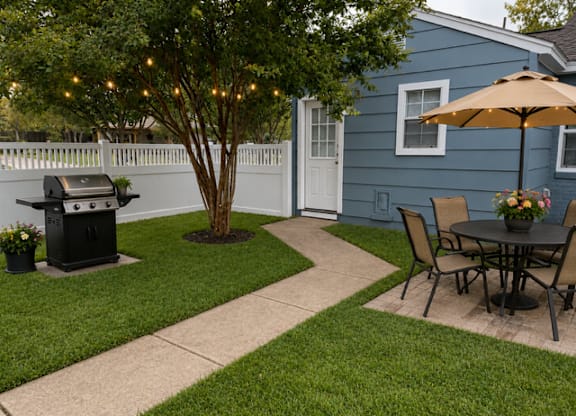 A blue house with a patio and a tree with lights.