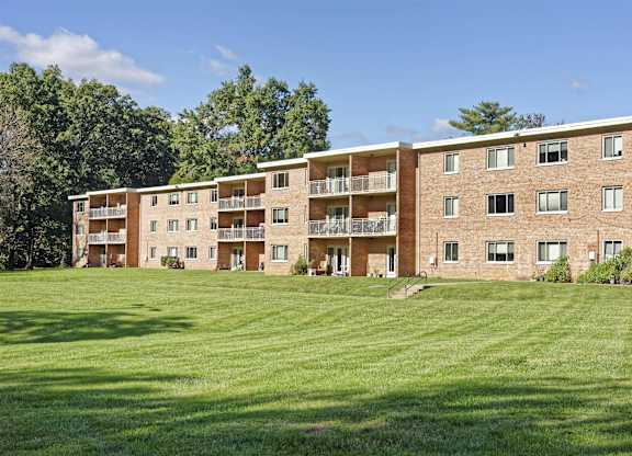 A large apartment complex with a green lawn in front.
