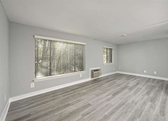 A room with a window and wooden flooring.
