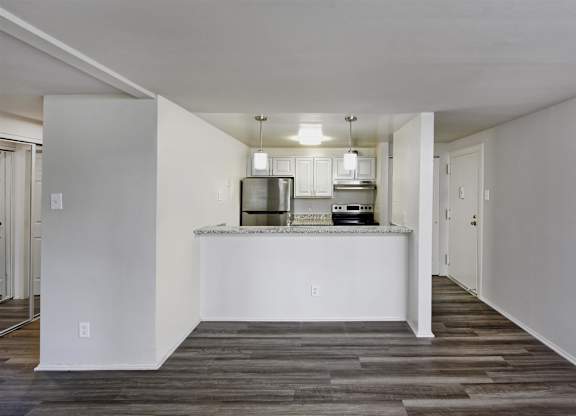 A kitchen with white cabinets and a white island with a countertop.