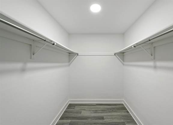 A long hallway with a wood floor and white walls.