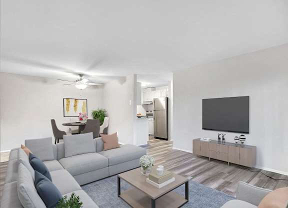 A living room with a grey couch, a coffee table, and a flat screen TV.