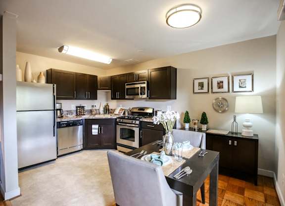 A kitchen with a table and chairs in the middle of it.