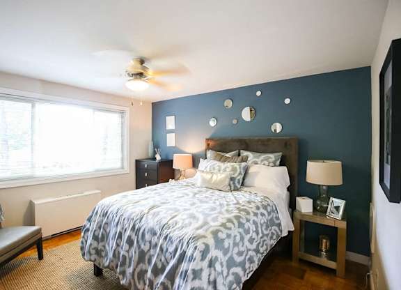 A bedroom with a bed, nightstands, and a ceiling fan.