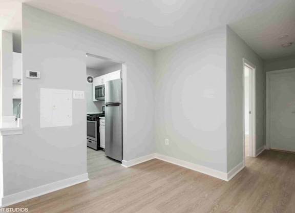 A kitchen with a refrigerator, oven, and microwave.