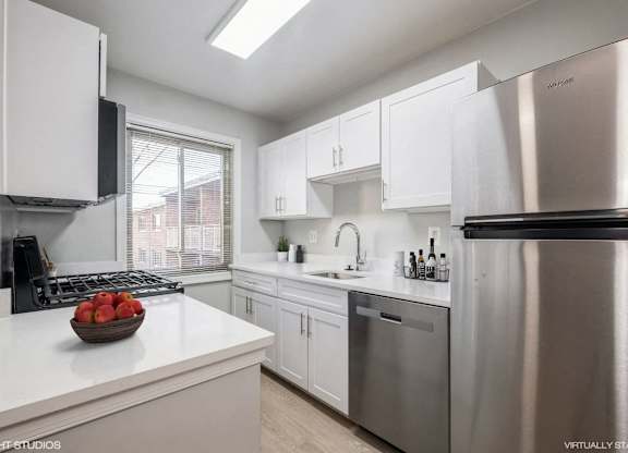 A modern kitchen with stainless steel appliances and white cabinets.