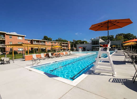 A swimming pool with a ladder and sunshades.